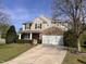 Beautiful two-story home with a stone accent facade, lush landscaping, a two-car garage, and a paved driveway at 141 Steel Hopper Way, Garner, NC 27529