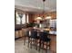 Well-lit kitchen with granite countertops, stainless steel appliances, island with bar stools, and warm wooden cabinetry at 141 Steel Hopper Way, Garner, NC 27529