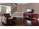 A living room with hardwood floors, a red TV stand, and a staircase at 141 Steel Hopper Way, Garner, NC 27529