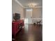 A living room with hardwood floors, a red TV stand, and a white door at 141 Steel Hopper Way, Garner, NC 27529
