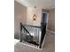 Second floor staircase landing with views to below, attractive black wrought iron and elegant hanging light fixture at 141 Steel Hopper Way, Garner, NC 27529