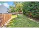 Green backyard with a wooden fence and fire pit area at 1433 Deltona Dr, Raleigh, NC 27615