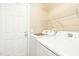 Well-lit laundry room with storage shelves, washer, and dryer at 1433 Deltona Dr, Raleigh, NC 27615