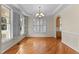 Sunlit dining area featuring hardwood floors, white trim, and elegant chandelier at 1526 Town Home Dr, Apex, NC 27502