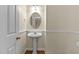 Neat half-bathroom with a pedestal sink, decorative mirror, and wood flooring, showcasing a functional and stylish space at 1526 Town Home Dr, Apex, NC 27502