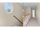 Upstairs hallway featuring a large oval window, carpeted floors, and a hanging light fixture at 1526 Town Home Dr, Apex, NC 27502