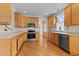 Well-lit kitchen boasting wooden cabinets, modern appliances, and hardwood floors at 1526 Town Home Dr, Apex, NC 27502