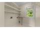 Bright laundry room with shelving and a window, offering a practical and organized space for laundry tasks at 1526 Town Home Dr, Apex, NC 27502