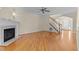 Bright living room featuring a fireplace, hardwood floors, and staircase leading to the second floor at 1526 Town Home Dr, Apex, NC 27502