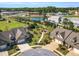 Aerial view of townhomes with manicured lawns and landscaping, pond, and commercial buildings nearby at 153 Telluride Trl, Garner, NC 27529