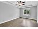 This bedroom features a ceiling fan, tray ceiling and a window offering natural light and outdoor views at 153 Telluride Trl, Garner, NC 27529