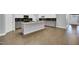 Modern kitchen featuring white cabinets, gray island, dark backsplash and stainless steel appliances at 153 Telluride Trl, Garner, NC 27529