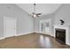 Bright living room with a fireplace, ceiling fan, wood flooring, and double doors to the outside at 153 Telluride Trl, Garner, NC 27529
