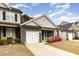 Inviting townhome featuring gray siding, stone accents, a red front door, and blooming shrubs at 178 Cullen Ct, Clayton, NC 27520