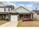 Charming home featuring gray siding, stone accents, a red front door, and a well-manicured lawn at 178 Cullen Ct, Clayton, NC 27520