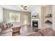 Comfortable living room with fireplace, ceiling fan, and a view of the landscaped backyard at 178 Cullen Ct, Clayton, NC 27520