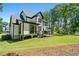 The back exterior features a covered porch with a wooden deck overlooking the expansive, well-manicured backyard at 188 E Antebellum Dr, Pittsboro, NC 27312