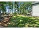 A serene backyard featuring a lush green lawn, mature trees, and a charming deck area for outdoor relaxation at 188 E Antebellum Dr, Pittsboro, NC 27312