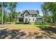 A house surrounded by lush trees with a screened-in porch overlooking a well manicured backyard at 188 E Antebellum Dr, Pittsboro, NC 27312
