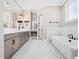 This bathroom features double sinks, marble countertops, a soaking tub, and a window for natural light at 188 E Antebellum Dr, Pittsboro, NC 27312
