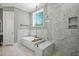 The primary bathroom features a tub, a glass shower, and beautiful marble-look wall and floor tile at 188 E Antebellum Dr, Pittsboro, NC 27312