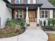 Inviting front porch with stone steps, decorative plants, and a glass-paneled front door, creating a warm and welcoming entrance at 188 E Antebellum Dr, Pittsboro, NC 27312