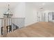 Hallway with chandelier, hardwood floors and iron railing at 188 E Antebellum Dr, Pittsboro, NC 27312
