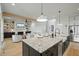 The kitchen features an oversized granite island that overlooks a living area with fireplace and a built-in bookcase at 188 E Antebellum Dr, Pittsboro, NC 27312