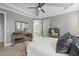 This main bedroom boasts light grey walls, tray ceiling, and mirrored dresser with a view to the ensuite bathroom at 188 E Antebellum Dr, Pittsboro, NC 27312