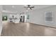 Open-concept living room features hardwood floors and a ceiling fan adjacent to modern kitchen at 201 Benton Dr, Oxford, NC 27565