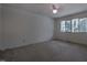 Bright bedroom with a ceiling fan, light-colored carpet, and a large window overlooking a wooded view at 206 Rochelle Dr, Knightdale, NC 27545