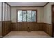 Spacious empty room featuring wood paneling and trim with a view of trees outside the large window at 206 Rochelle Dr, Knightdale, NC 27545