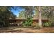 Brick ranch home nestled among mature trees and diverse landscaping with a partially visible facade at 206 Rochelle Dr, Knightdale, NC 27545