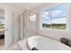Bright bathroom features a glass shower, a soaking tub, and a view of the neighborhood at 21 Green Links Dr, Cameron, NC 28326
