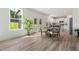 Open-concept dining area with wood floors, stylish furniture, and backyard views at 21 Green Links Dr, Cameron, NC 28326