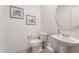 Clean powder room featuring a pedestal sink, toilet, and elegant decor at 21 Green Links Dr, Cameron, NC 28326
