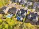 Aerial view of a home with a pool and a lush backyard surrounded by mature trees and neighboring homes at 212 Blue Granite Dr, Holly Springs, NC 27540