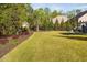 Lush backyard featuring a well-manicured lawn and a variety of trees and shrubs, offering privacy at 212 Blue Granite Dr, Holly Springs, NC 27540