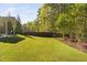 Spacious backyard with green lawn, mature trees and shrubs, creating a private outdoor space at 212 Blue Granite Dr, Holly Springs, NC 27540