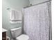 Clean bathroom with a toilet, towel rack, and a shower with a patterned curtain at 212 Blue Granite Dr, Holly Springs, NC 27540