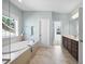 Bright bathroom features a soaking tub under a window, a glass enclosed shower and double sink vanity at 212 Blue Granite Dr, Holly Springs, NC 27540