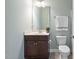 Well-lit bathroom features a single sink vanity, toilet, and towel rack with neutral wall color at 212 Blue Granite Dr, Holly Springs, NC 27540