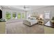 Spacious bedroom with large windows, a ceiling fan, plush carpet, and a tufted headboard creating a relaxing retreat at 212 Blue Granite Dr, Holly Springs, NC 27540