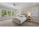 Bright bedroom with large windows, plush carpet, and a tufted headboard creating a cozy and elegant atmosphere at 212 Blue Granite Dr, Holly Springs, NC 27540
