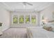 Spacious bedroom featuring a ceiling fan, large windows, and plush carpet with a glimpse of a plush, comfortable bed at 212 Blue Granite Dr, Holly Springs, NC 27540