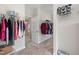 Large walk-in closet with clothes racks on both sides leading to a bathroom at 212 Blue Granite Dr, Holly Springs, NC 27540