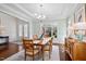 Dining room with natural light, wood table with seating for six, and a view of the front yard at 212 Blue Granite Dr, Holly Springs, NC 27540