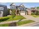 Inviting two-story home with a manicured lawn, gray siding, multi-car garage, and an American flag on the porch at 212 Blue Granite Dr, Holly Springs, NC 27540