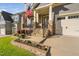 Home exterior features a covered porch, stone accents, a manicured lawn, and a two-car garage at 212 Blue Granite Dr, Holly Springs, NC 27540