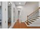 Elegant foyer with hardwood floors, wood stairs, and a glass door and transom showcasing the home's inviting entrance at 212 Blue Granite Dr, Holly Springs, NC 27540